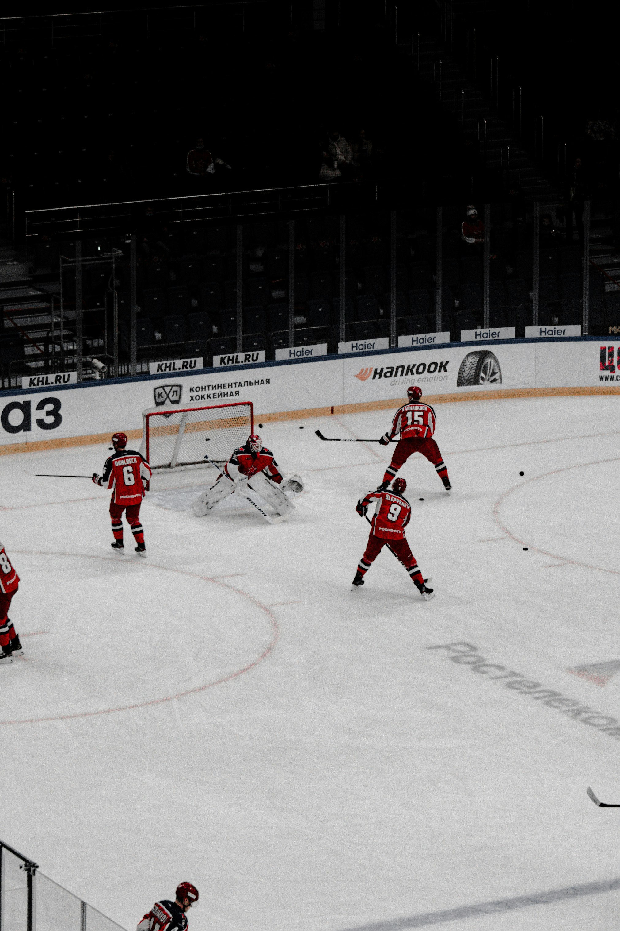 people playing ice hockey on ice field during daytime